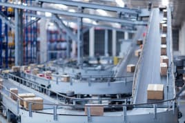 Conveyor belt moving boxes in a manufacturing facility