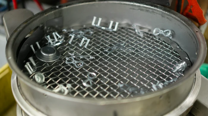 Final metal manufactured parts shaking in a container